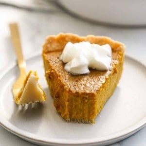 a half eaten slice of pumpkin pie with whipped cream