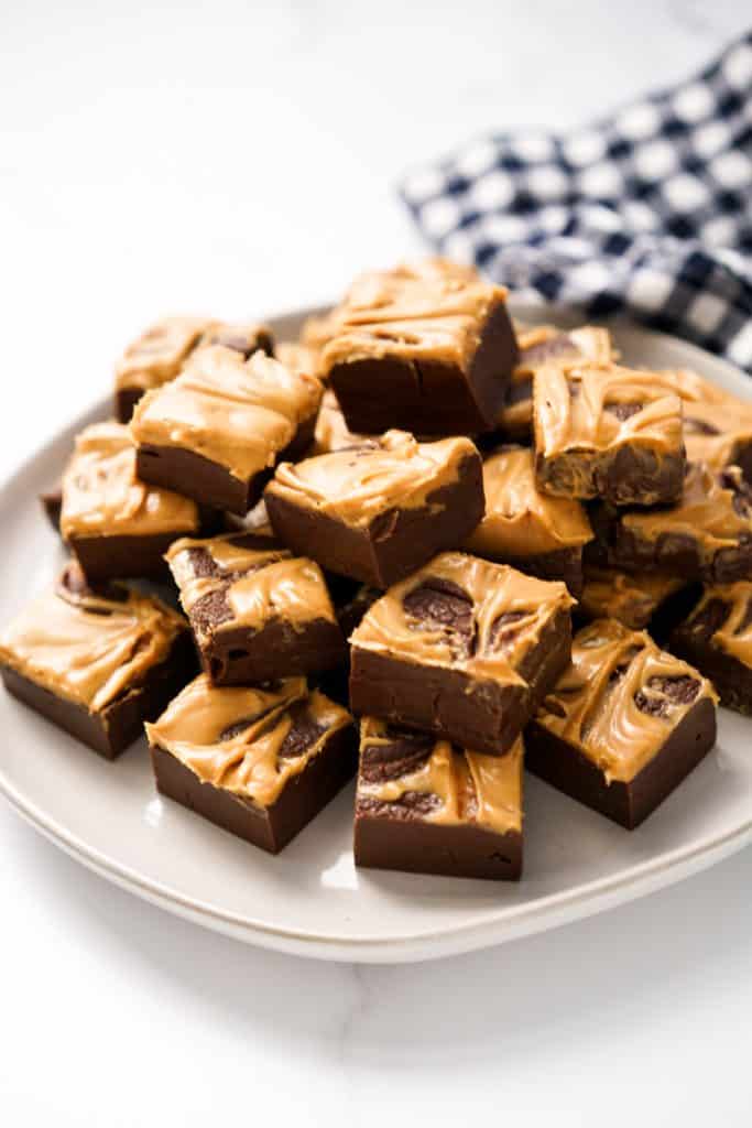 A plate topped with lots of chocolate fudge with peanut butter on top