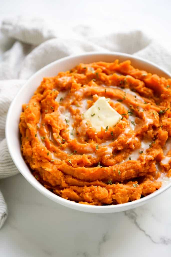 A large bowl of mashed sweet potatoes with swirls on top