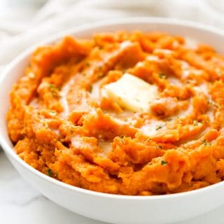 closeup of mashed sweet potatoes topped with butter