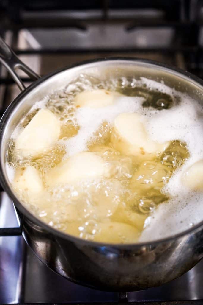 Boiling big chunks of potatoes in water in a pot