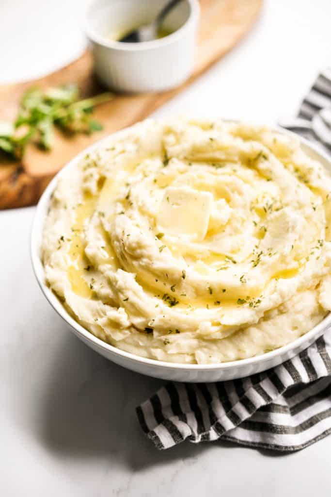 A bowl of creamy mashed potatoes topped with melted butter