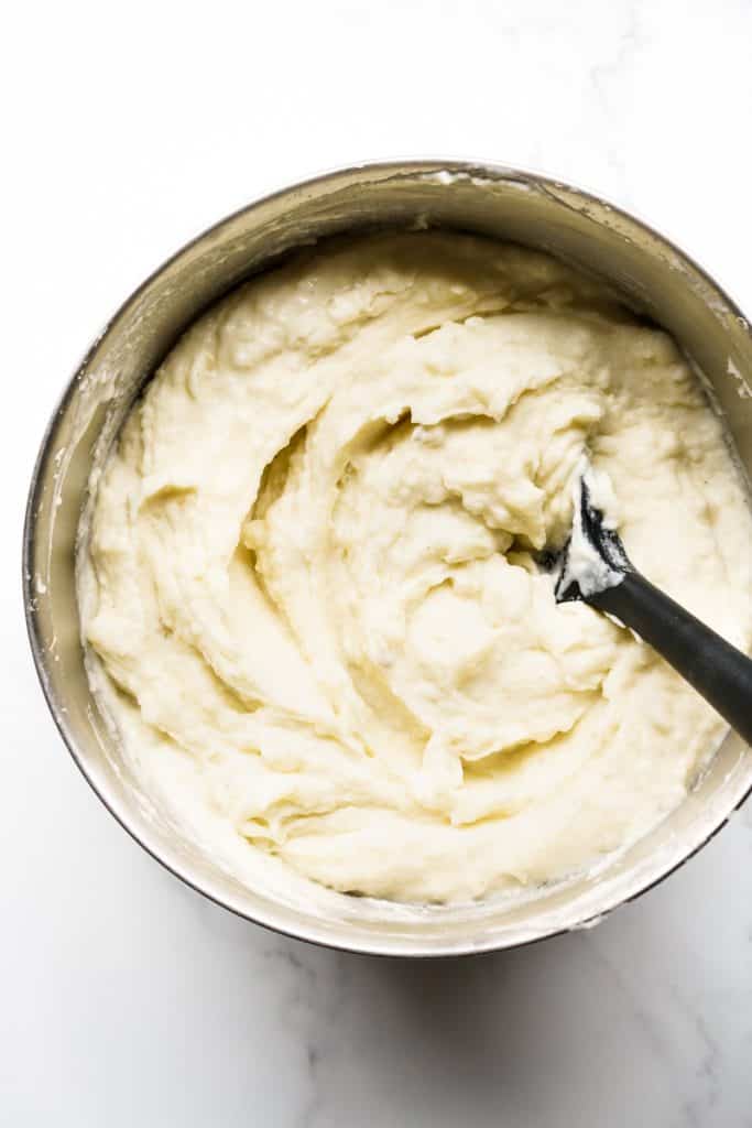 Silky and creamy mashed potatoes in a mixing bowl