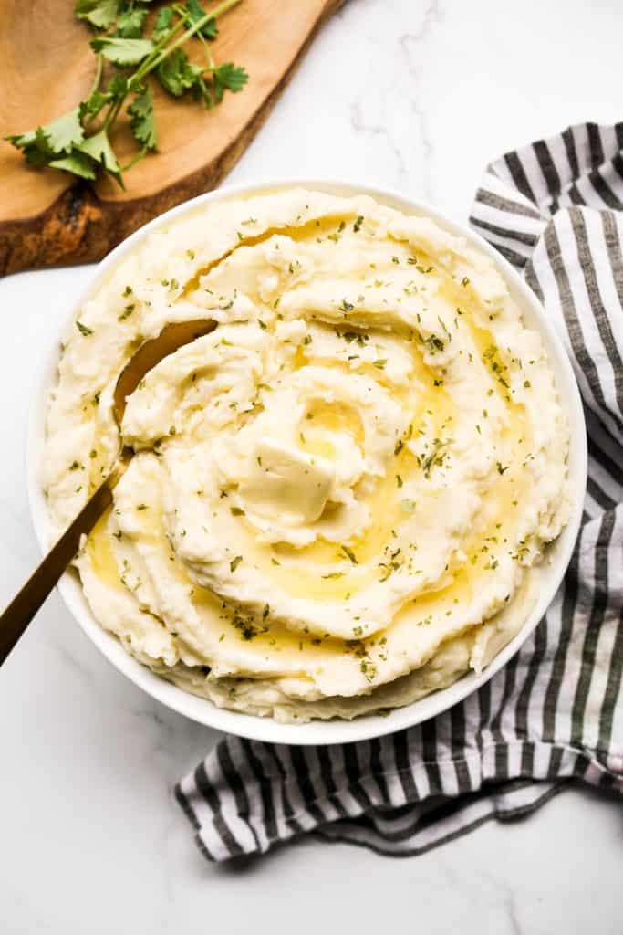 Top down view of mashed potatoes made with heavy cream and topped with butter