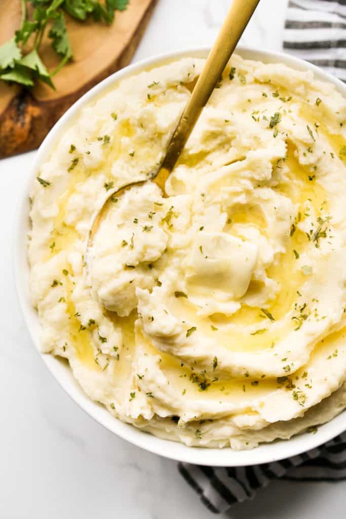 Scooping out some mashed potatoes in a bowl with a spoon