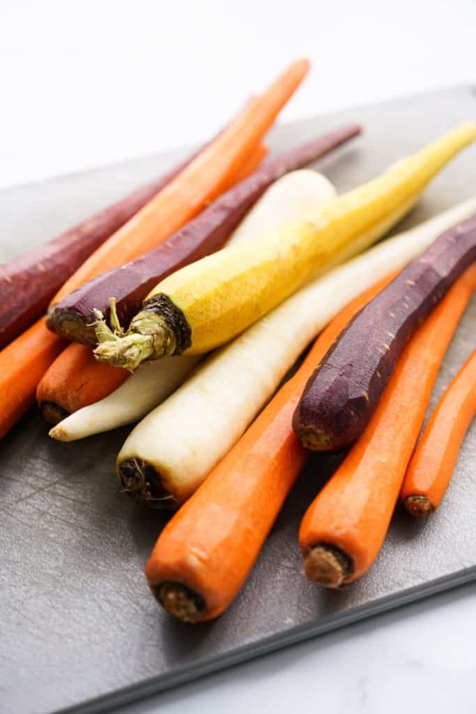 Raw peeled carrots on cutting board