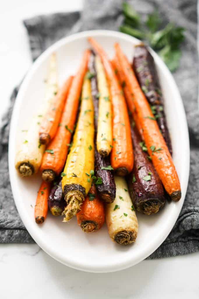 A plate of colorful whole roasted carrots