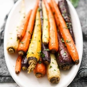 A plate piled high with colorful whole stalks of carrots