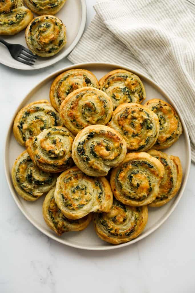A plate of puff pastry spinach pinwheels from the top down