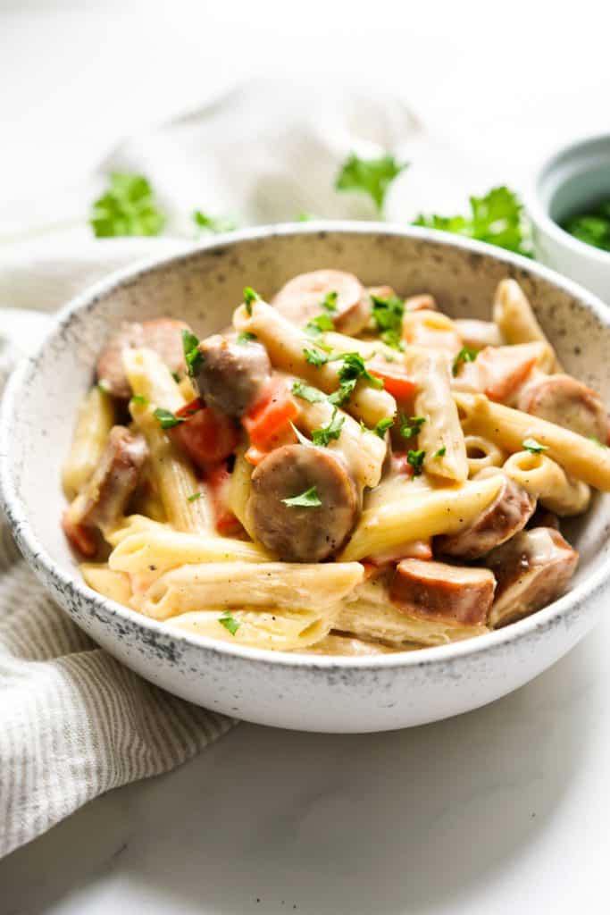 A bowl of creamy pasta tossed with smoked sausage and bell peppers
