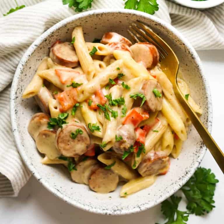 A bowl of pasta tossed in cajun alfredo sauce and sausage