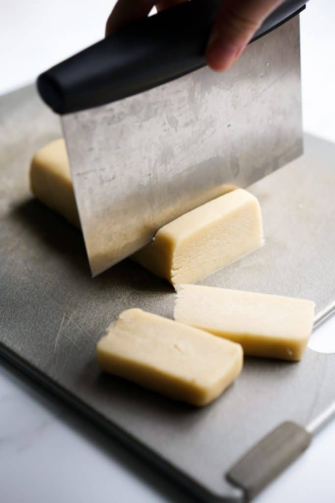 Slicing shortbread cookie dough with pastry cutter