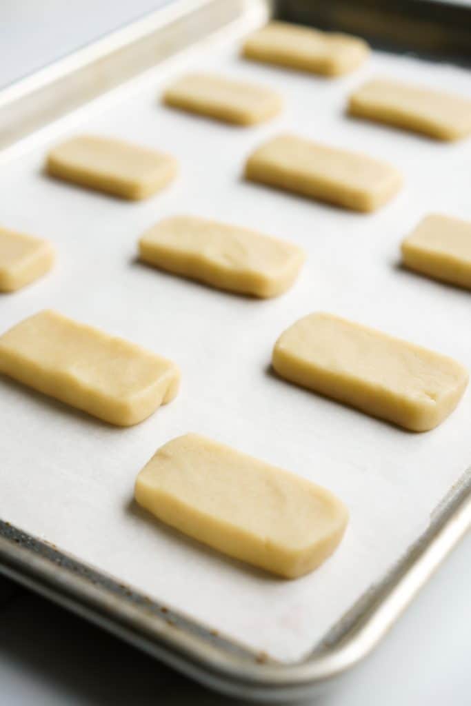 unbaked rectangular shortbread cookies on baking sheet