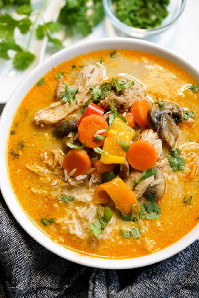 Closeup of a bowl of creamy coconut curry chicken and rice soup