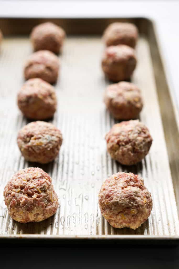 Lining up cream cheese sausage balls on baking sheet