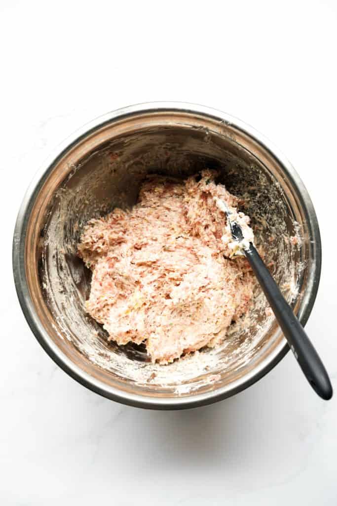 Raw cream cheese sausage ball mixture in a large mixing bowl