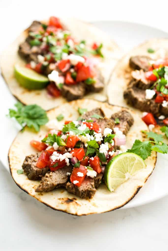 Flour tortillas topped with grilled steaks, pico de gallo, cheese and cilantro