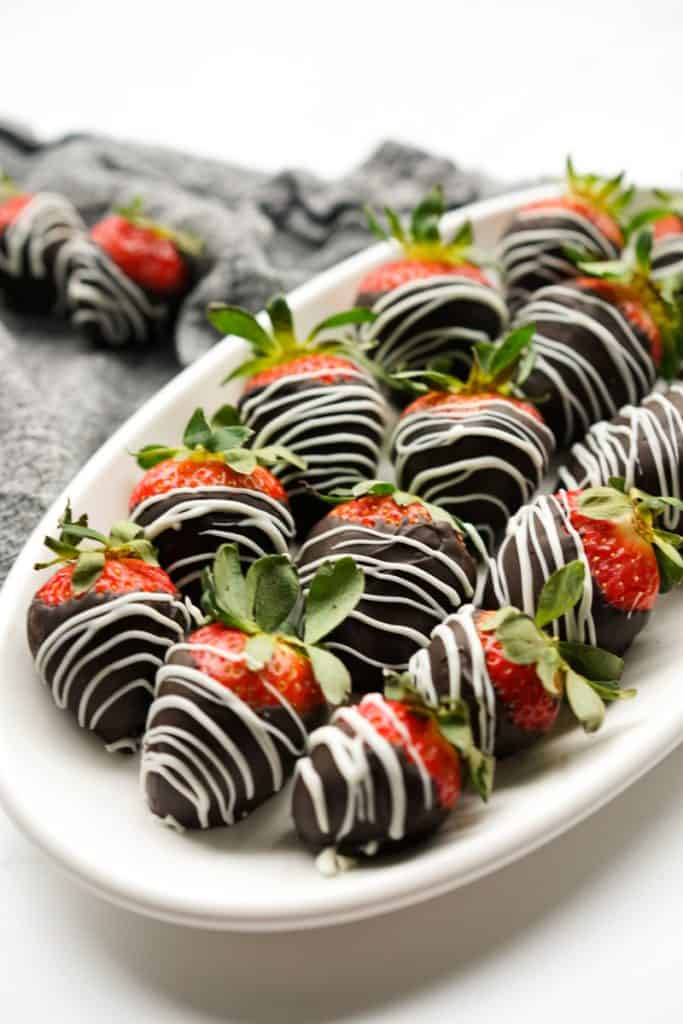 Chocolate covered strawberries lined up on a plate