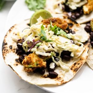 Flour tortilla topped with avocado and slaw