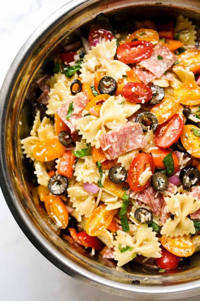 Top down view of half of a bowl of Italian bow tie pasta salad
