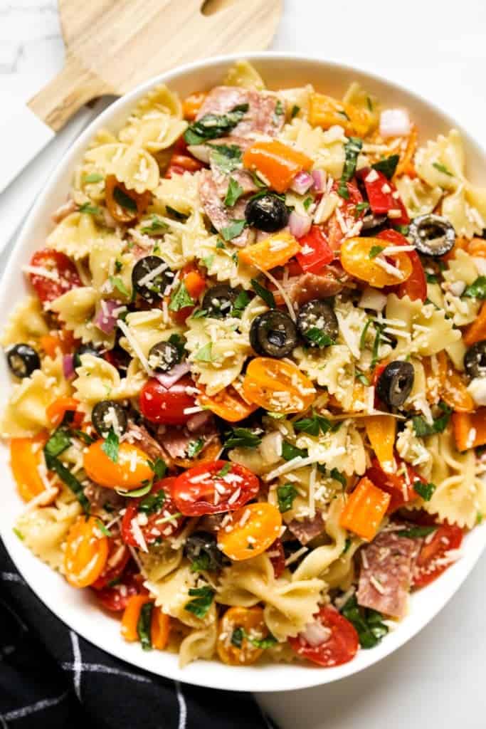 Bow tie pasta tossed with tomatoes, olives, bell peppers, parmesan and red onions
