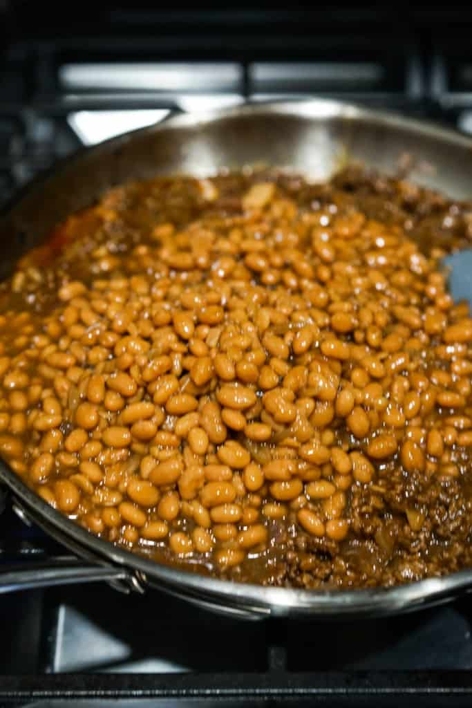 Baked beans added to ground beef in the skillet