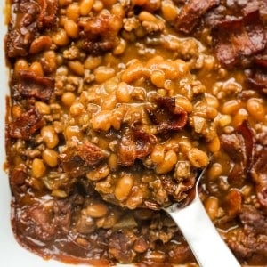 Scooping out some baked beans with ground beef and bacon