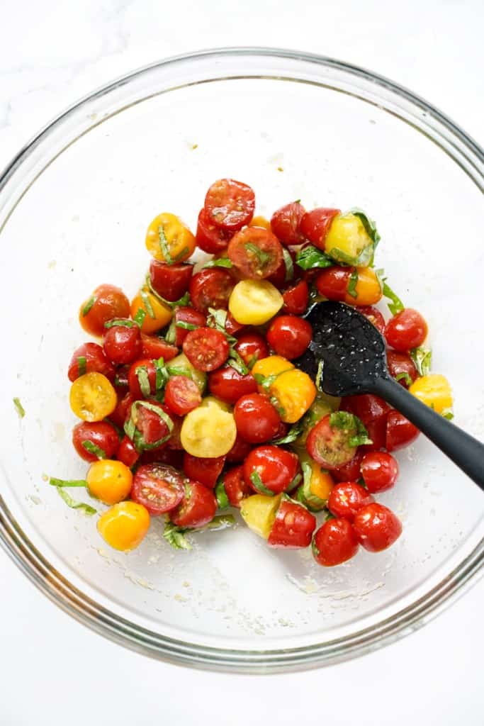 A bowl of cherry tomato, basil and garlic mixture