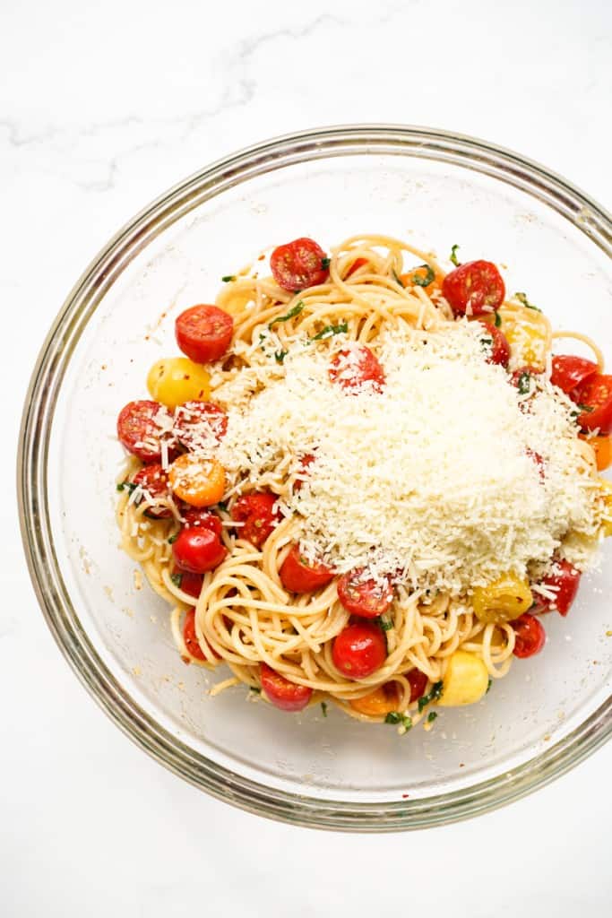 Parmesan cheese on top of cherry tomato pasta