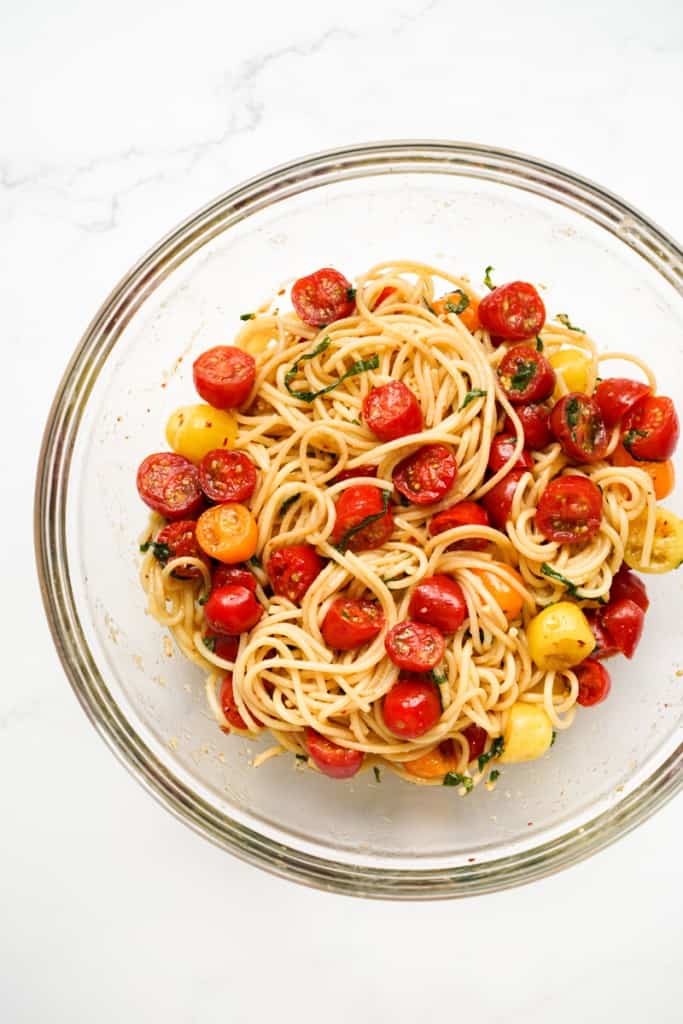 Spaghetti and cherry tomato mixture in a large mixing bowl