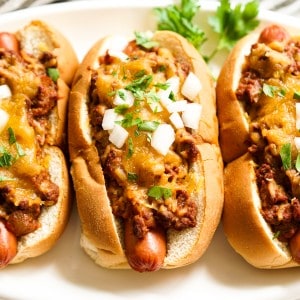Three large hot dogs loaded with chili and cheese
