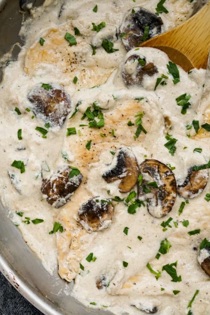 Closeup of a pieces of chicken cutlet covered in creamy mushroom sauce