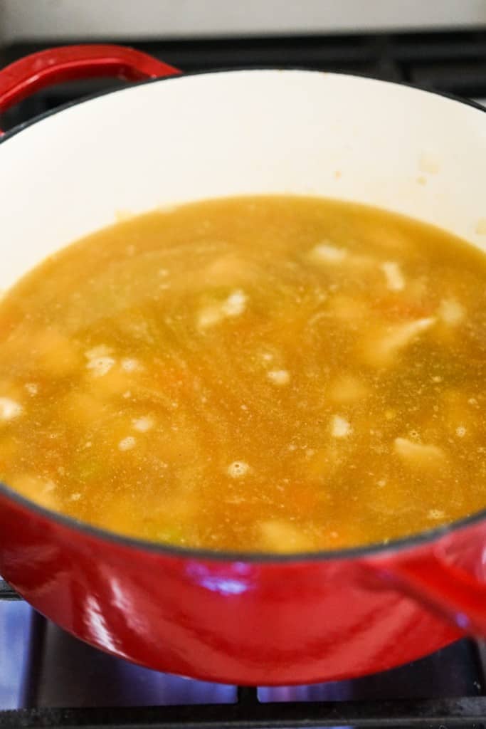 Chicken broth added to Dutch oven