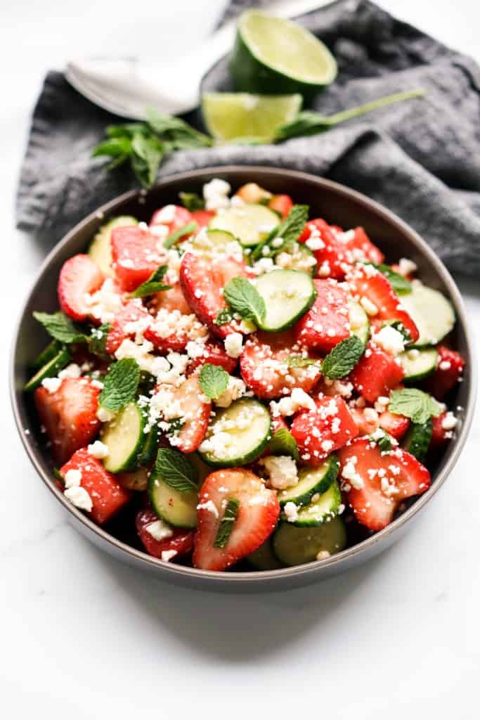 A vibrant bowl of watermelon, strawberries, cucumber, mint and feta tossed in honey lime dressing