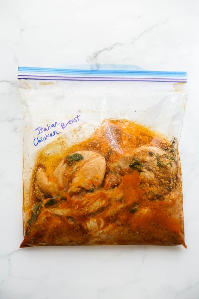 Chicken breasts marinated in Italian seasonings in a zip lock bag