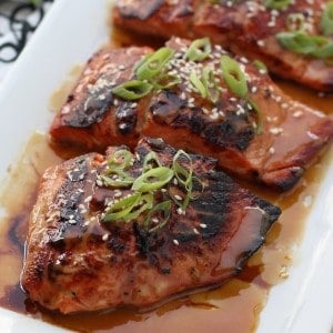 Salmon coated with miso soy glazed on a plate topped with green onions