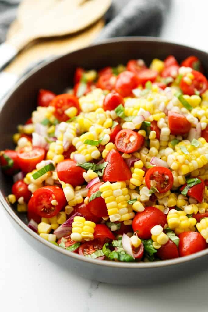 A bowl loaded with fresh cherry tomato and corn salad