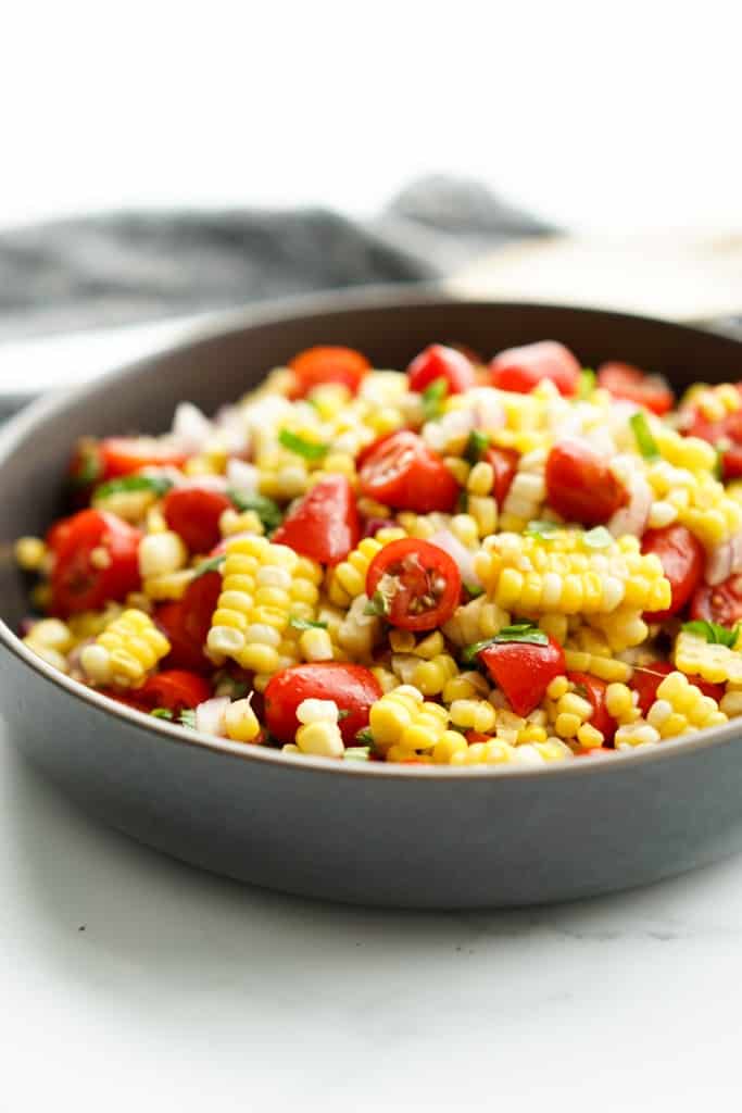 A bowl of fresh corn cherry tomato salad