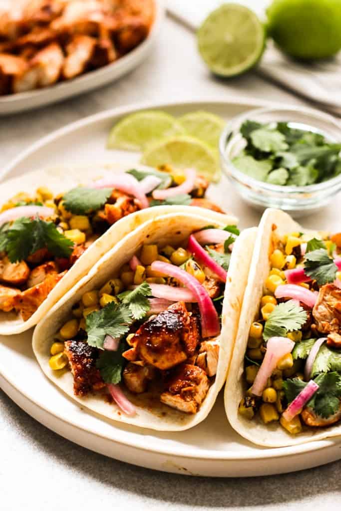 Flour tortillas topped with barbecue chicken, red onions and corn