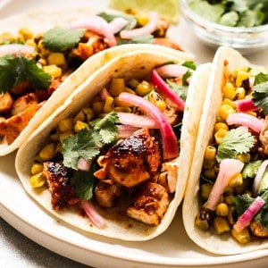 barbecue chicken taco topped with corn and red onions
