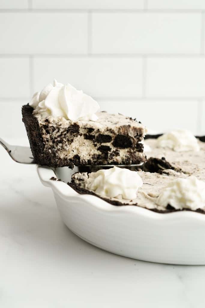 Lifting up a piece of oreo cream pie using a cake knife