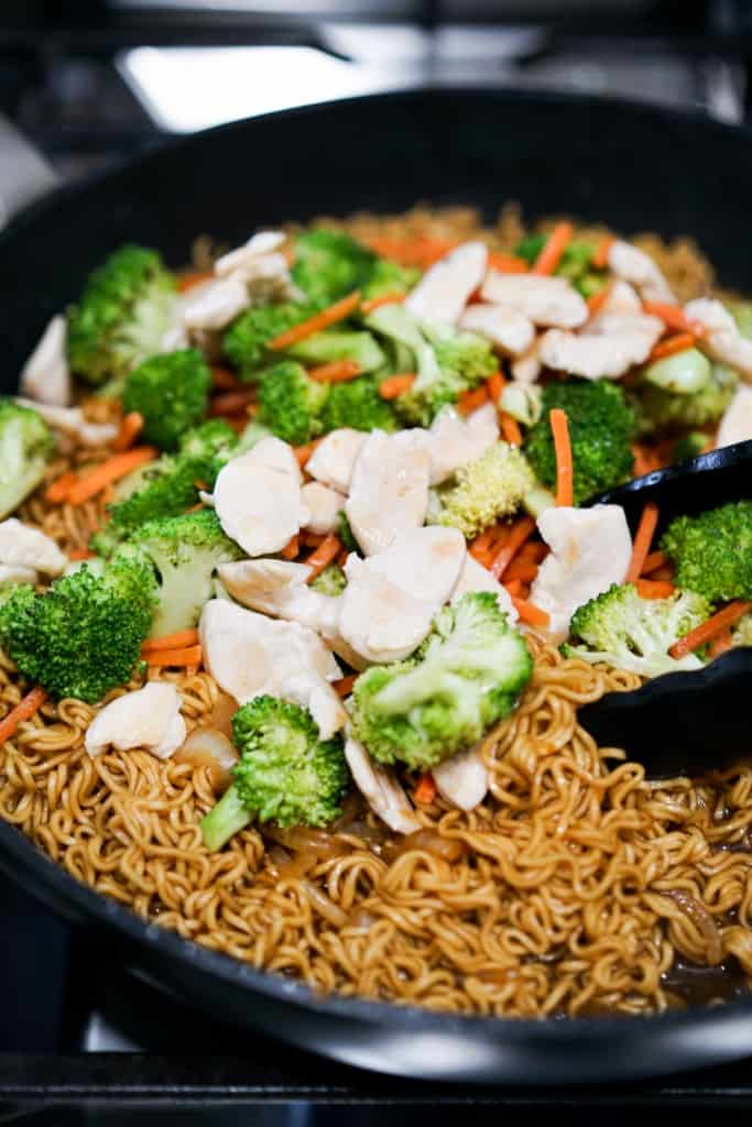 Ramen noodles, chicken, broccoli and carrots in a skillet