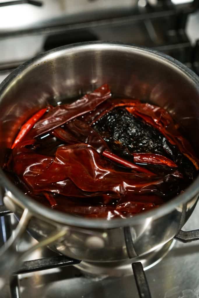 Different chilies in a pot with water