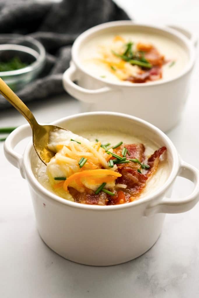 Spooning out some potato bacon soup from a bowl