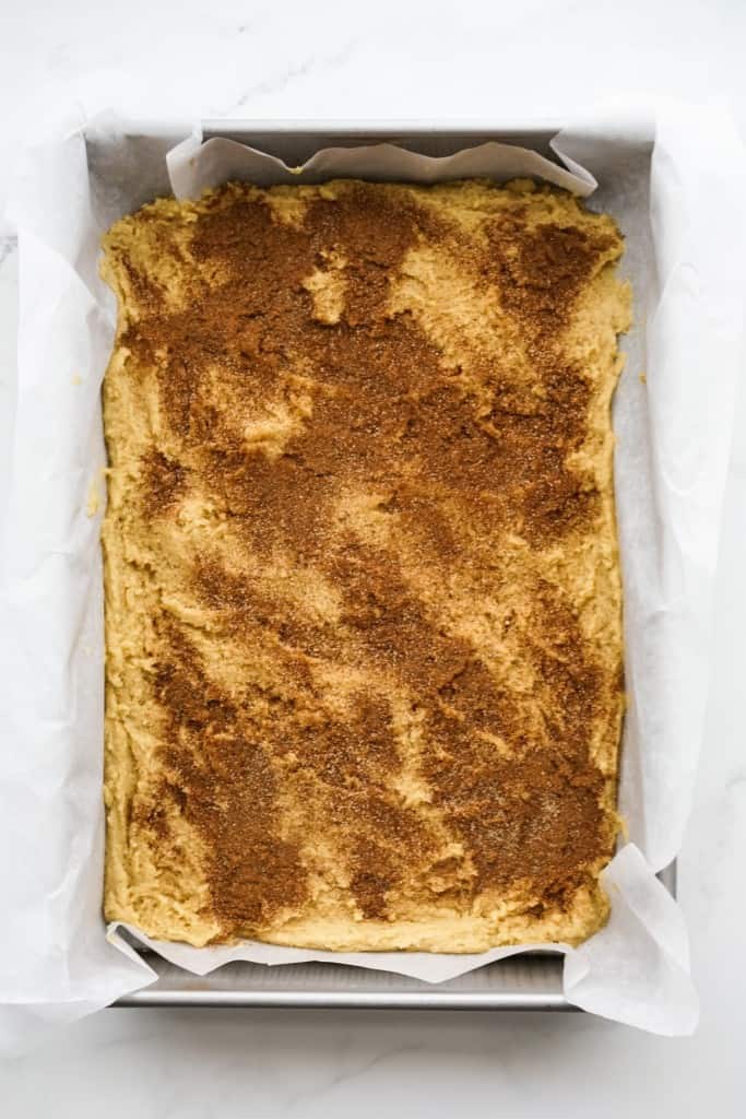 Dough with cinnamon sugar dusting on top in a baking dish