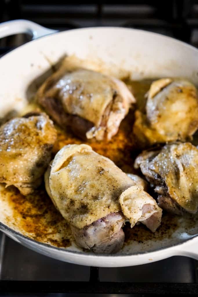 Searing skin-on chicken thighs on a braiser on stovetop