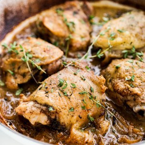 Braised chicken thighs with white wine and topped with fresh thyme herbs