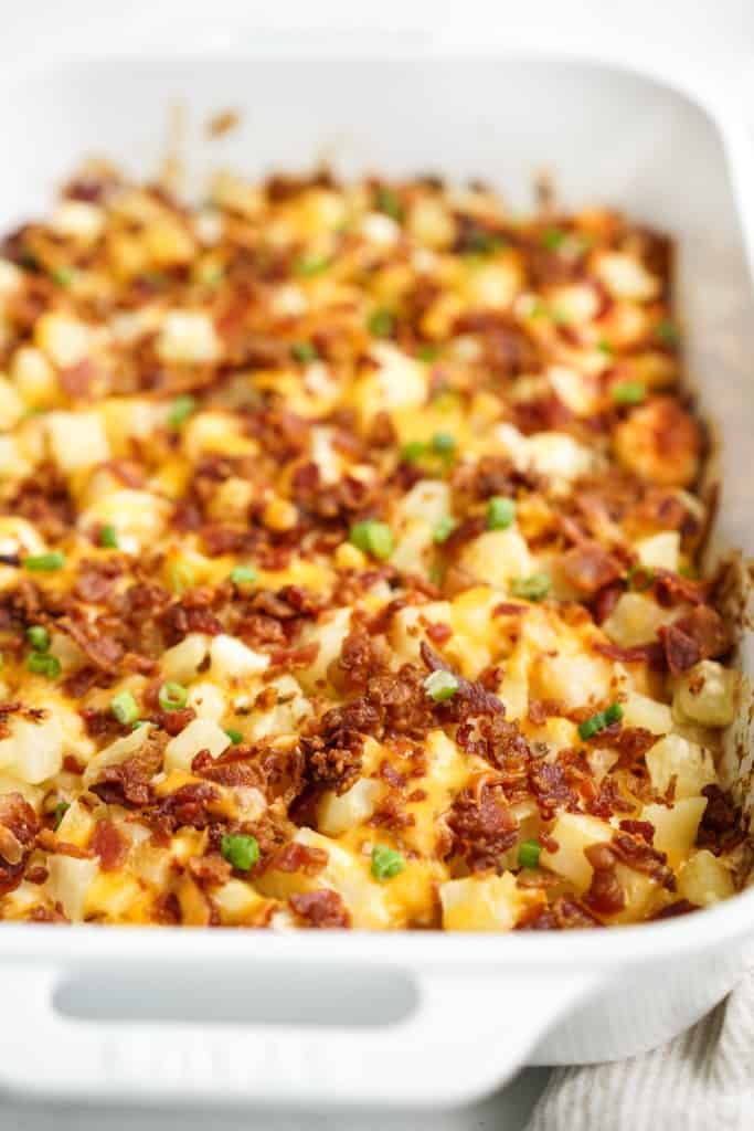 Side view of loaded baked potato casserole topped with bacon and cheese