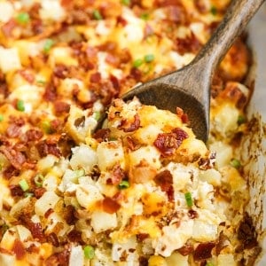 Scooping out some potatoes from a loaded baked potato casserole