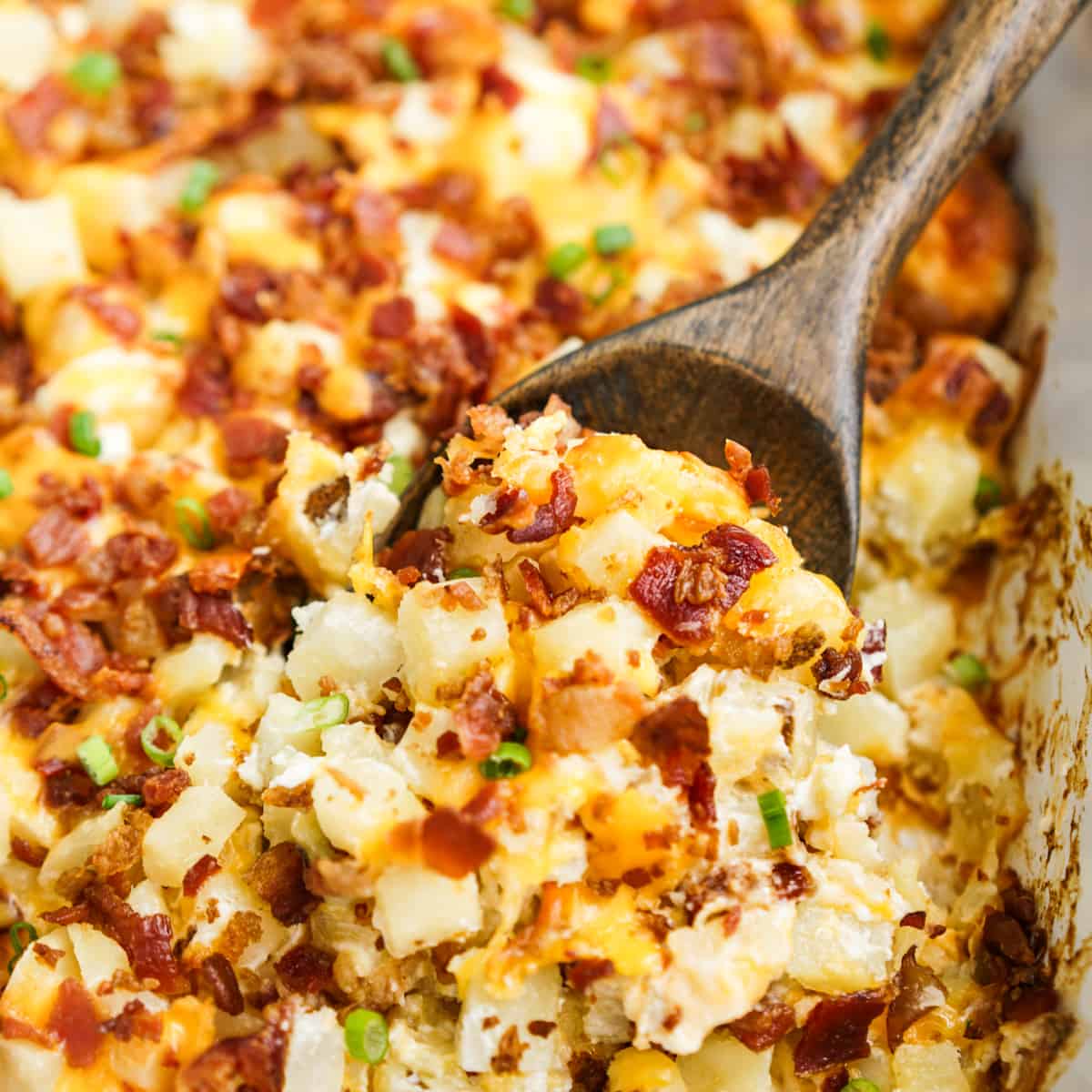 Scooping out some potatoes from a loaded baked potato casserole